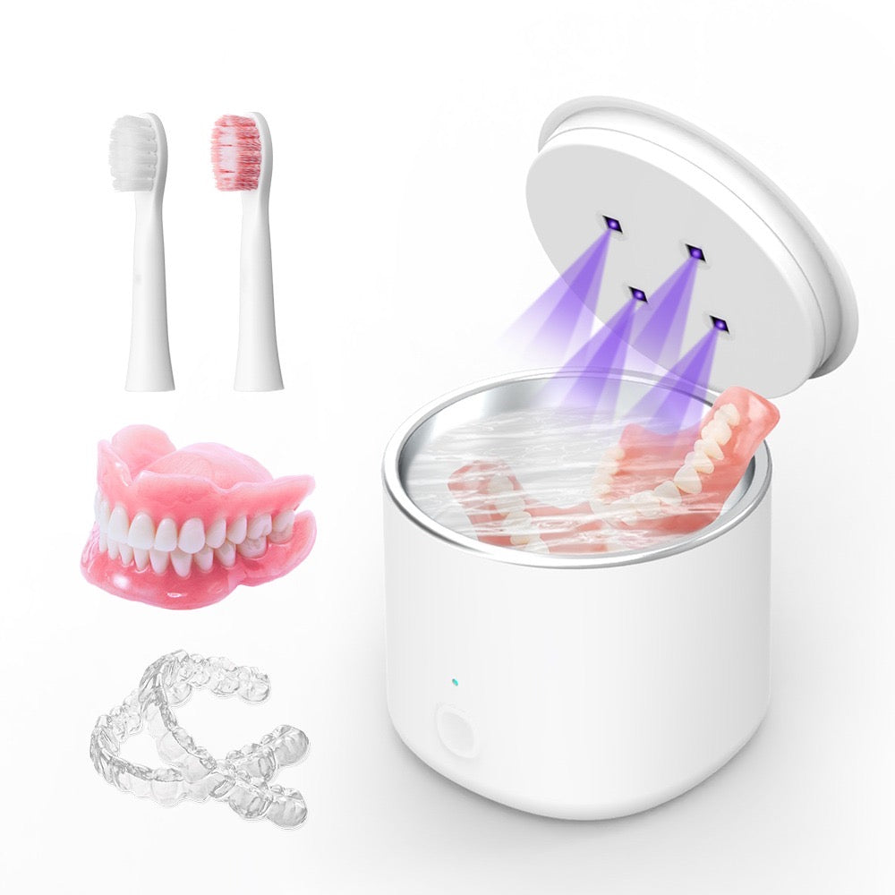 White UV sterilizer with dental tools including a toothbrush, dentures, and clear aligners on a white background.